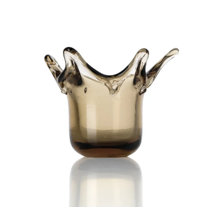 Glass candle holder with crown shape on a white background
