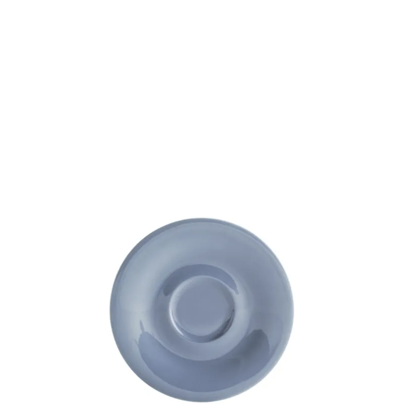 Eine runde, flache, hellblaue Untertasse aus Keramik ist im Bild. Die Tassenfläche ist glatt und glänzend, der Rand leicht nach oben gebogen. Im Zentrum der Untertasse befindet sich eine subtile Vertiefung, die für eine Tasse vorgesehen ist. Der Hintergrund ist schlicht und unauffällig, wodurch die Untertasse im Fokus steht.