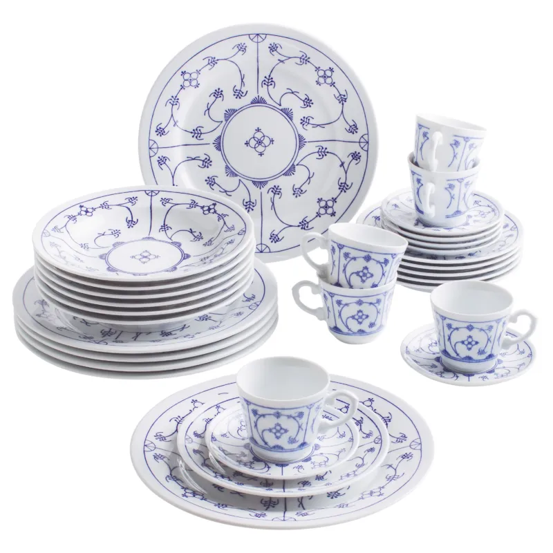 Eine elegant arrangierte Geschirrkollektion aus Porzellan mit blau-weißen Blumenmustern. Die Kollektion umfasst verschiedene Teller, darunter flache und tiefe, sowie Tassen und Untertassen. Im Hintergrund sind mehrere Tellerstapel sichtbar, während im Vordergrund Tassen, die auf einem kleinen Teller stehen, und eine größere Servierplatte zu sehen sind. Die feinen Details und filigranen Muster verleihen dem Geschirr einen klassischen, ansprechenden Look.