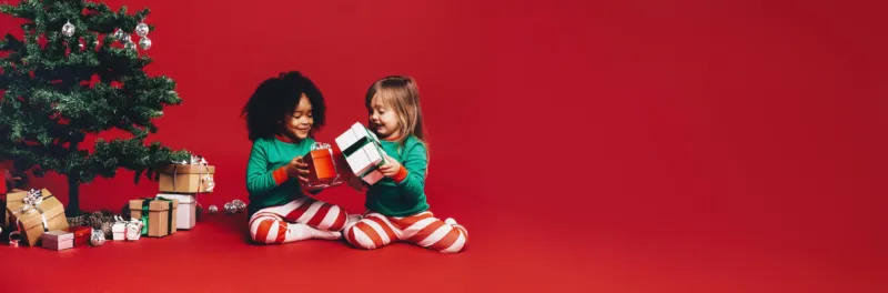 Spritzschutz-Fröhliche Kinder tauschen Weihnachtsgeschenke aus